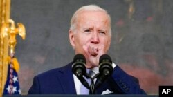 TƯ LIỆU - Tổng thống Joe Biden ho khi phát biểu về "Đạo luật Giảm Lạm phát năm 2022" trong Phòng Quốc Yến của Nhà Trắng ở Washington, ngày 28 tháng 7 năm 2022.