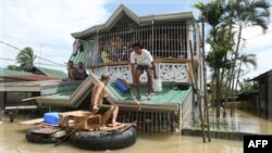 Cư dân sử dụng một chiếc bè tự chế để di chuyển tại thị trấn Calumpit, tỉnh Bulacan, Philippines, ngày 3/10/2011